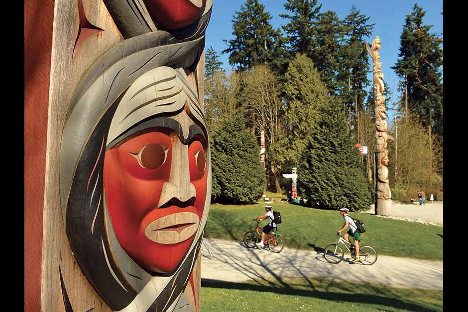 Totem pole and cyclists in Stanley Park